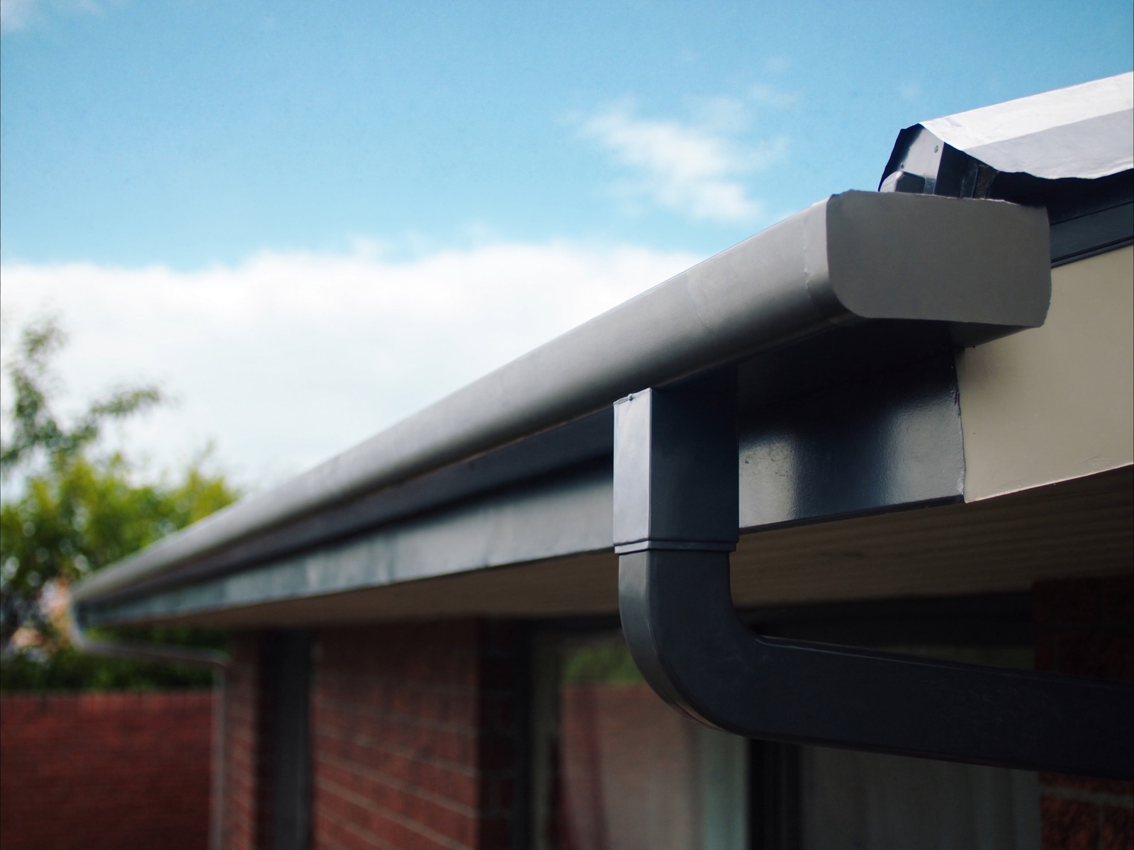 New steel guttering and downpipe on a brick Australian home